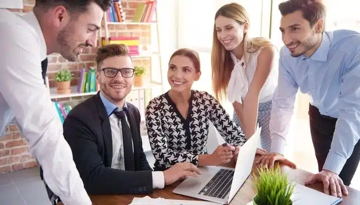 Office workers surrounding desk area