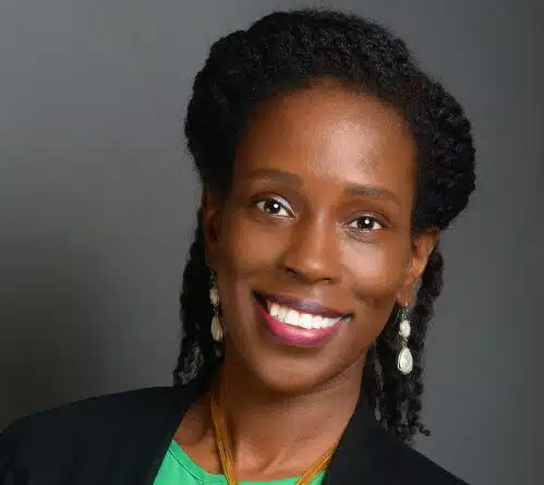 CNP, April Carter smiling with a green professional shirt and black suit jacket