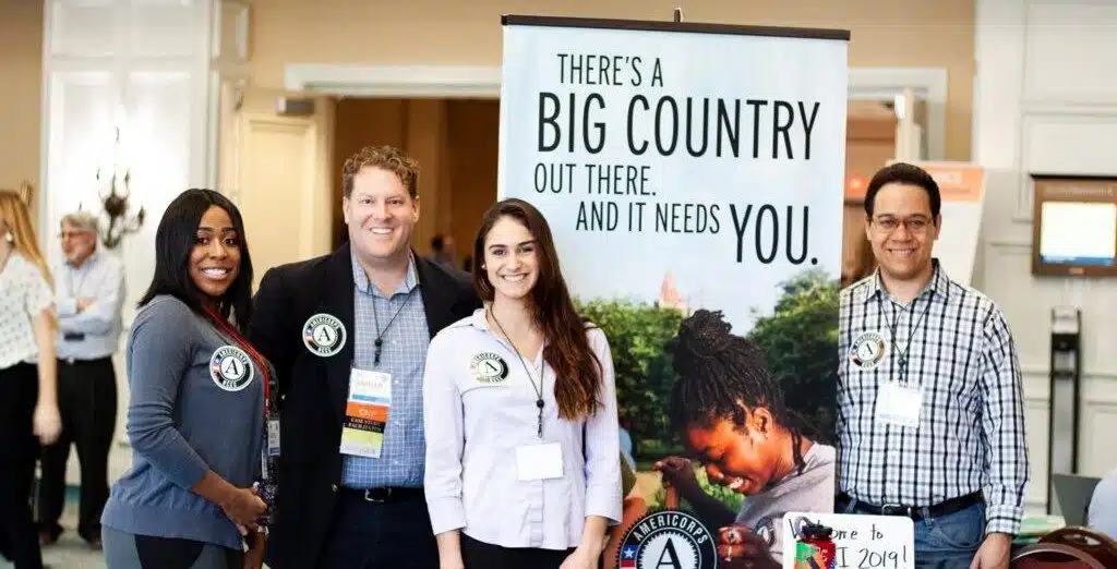 AmeriCorps NCCC Members in front of booth at conference