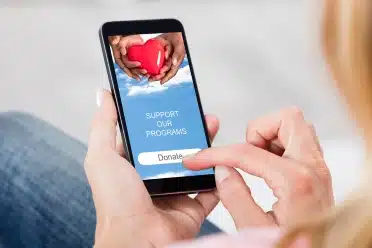 Woman holding a phone with text-to-donate on the screen