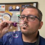 Michael Ash, CNP Headshot. White male blowing bubble in office setting