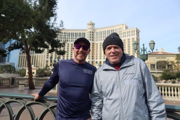 Two Caucasian Men smiling in front of the Bellagio in Las Vegas wearing running clothes 