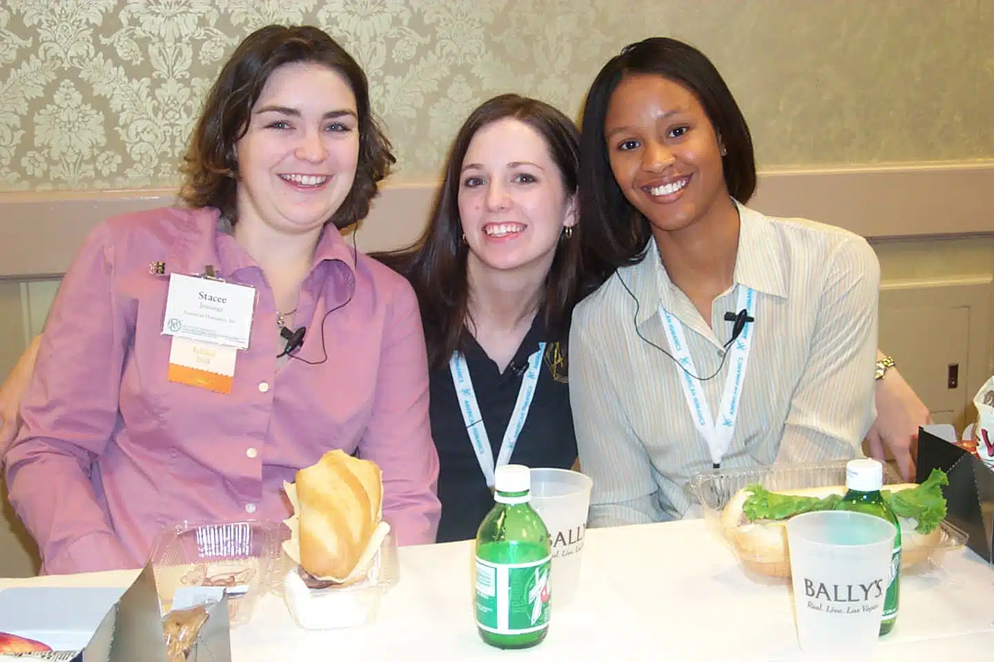 Three nonprofit professional students smiling at a table