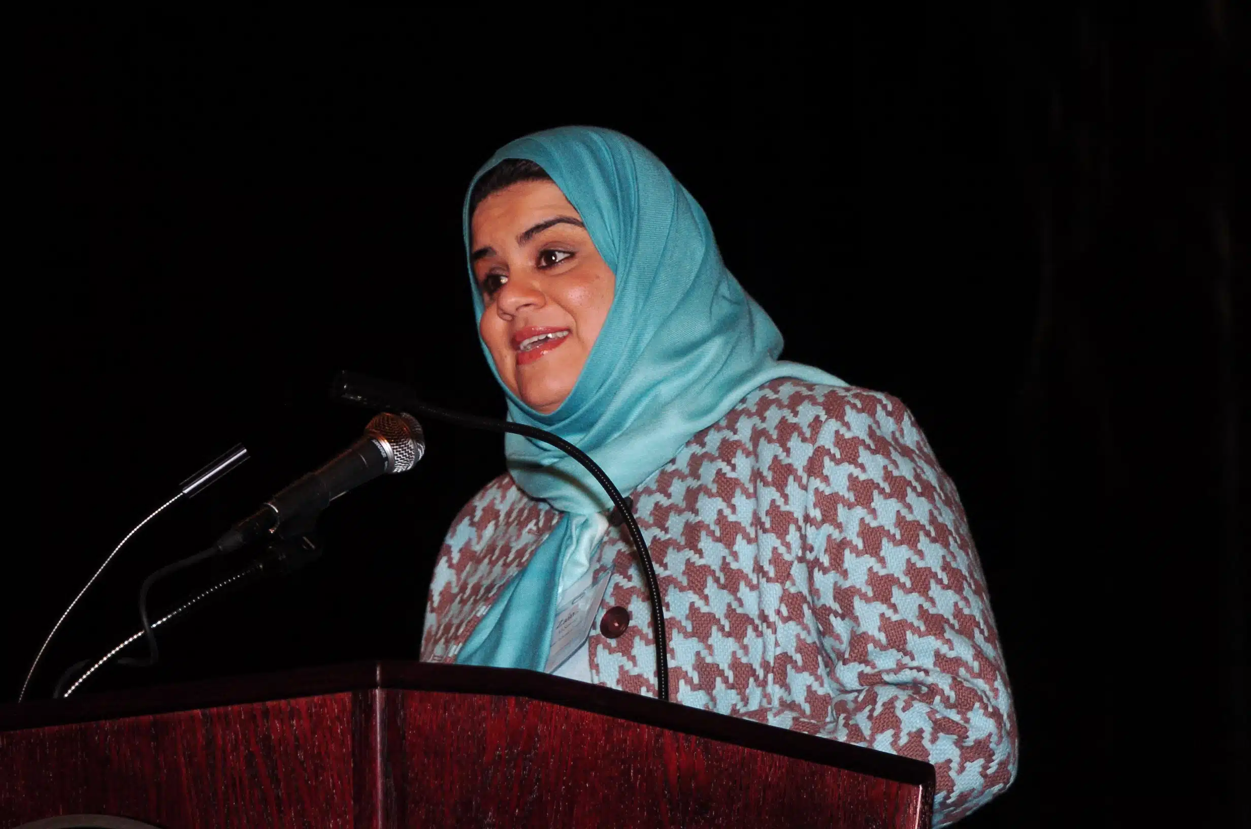 Woman in a headdress speaking into a microphone