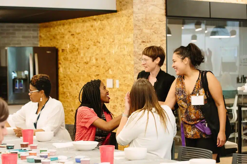 Co.act Detroit serves as a vital resource hub. Shown here is their office holding an event with Charnar Sanders's smiling and greeting people in their Detroit office