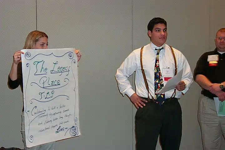 Man in a colorful vintage tie and white shirt presenting at a conference