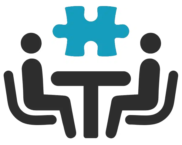 Two stick figures sitting at a table with a puzzle piece in between their faces to signify they are working together to solve difficult problems as Advanced CNPs