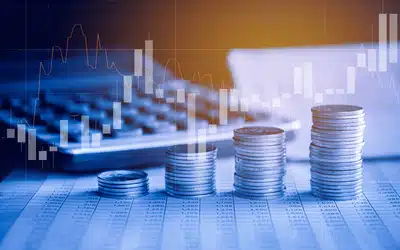 Coins stacked on a desk with a bar graph overlay.