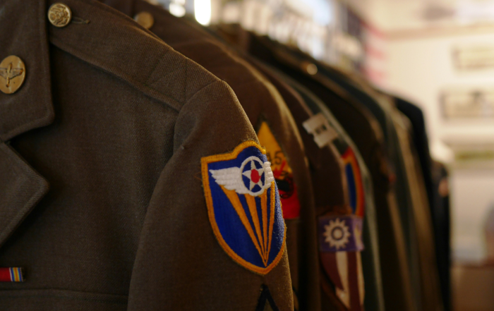 Military uniforms hung up in a row