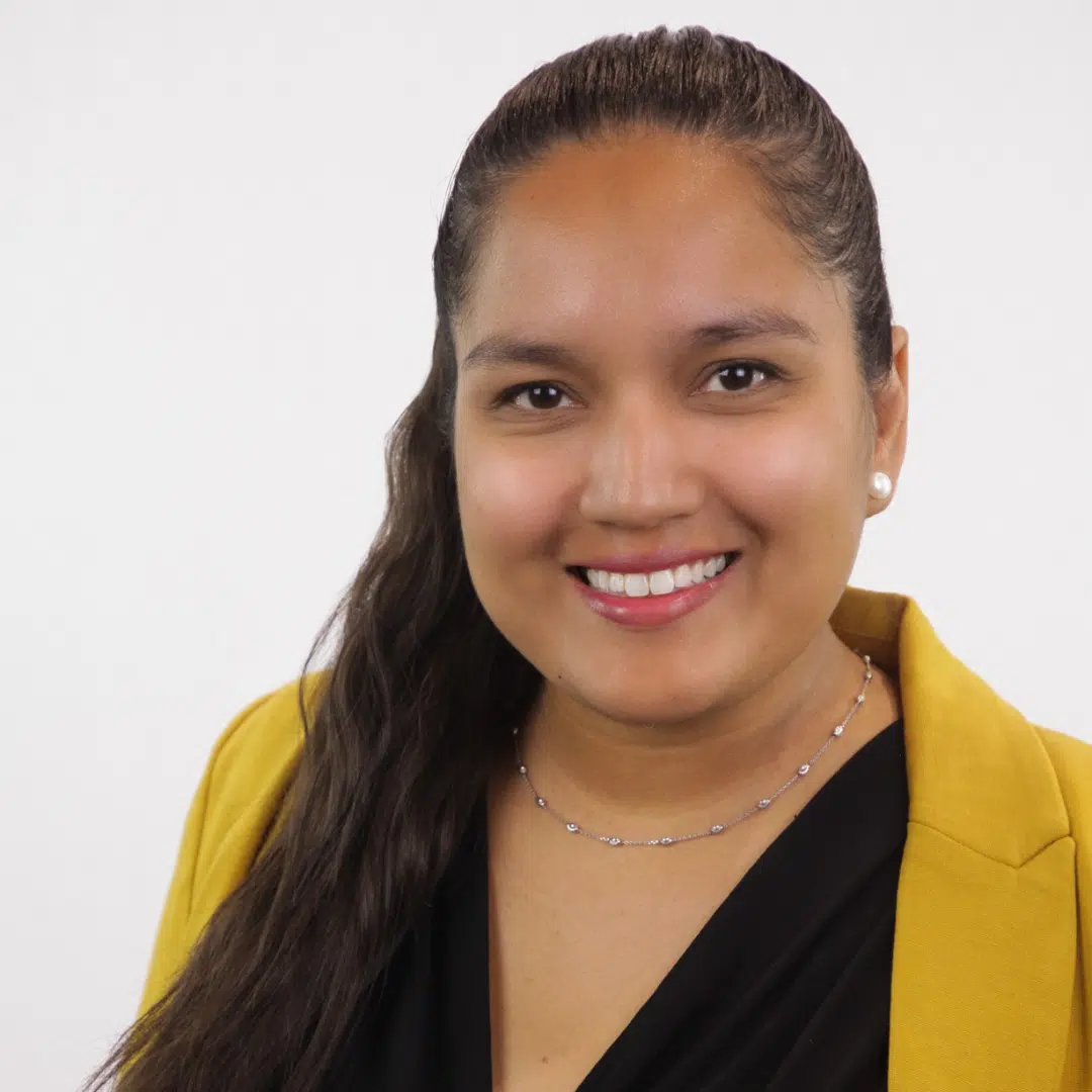 Certified Nonprofit Professional, Rebecca Herrera smiling in a professional yellow blazer and black shirt