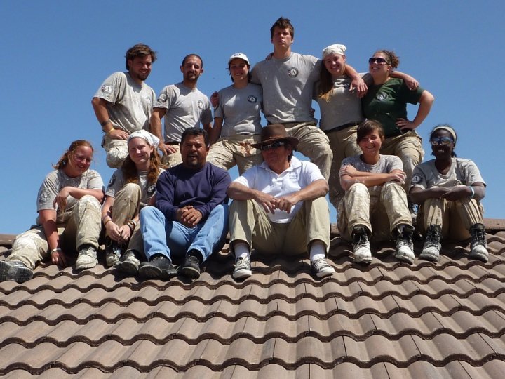 A group of Americorps NCCC members on top of a roof wearing matching uniforms