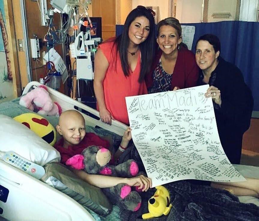 Carly St. Onge posing next to a Logan Health Childrens Hospital pediatric patient