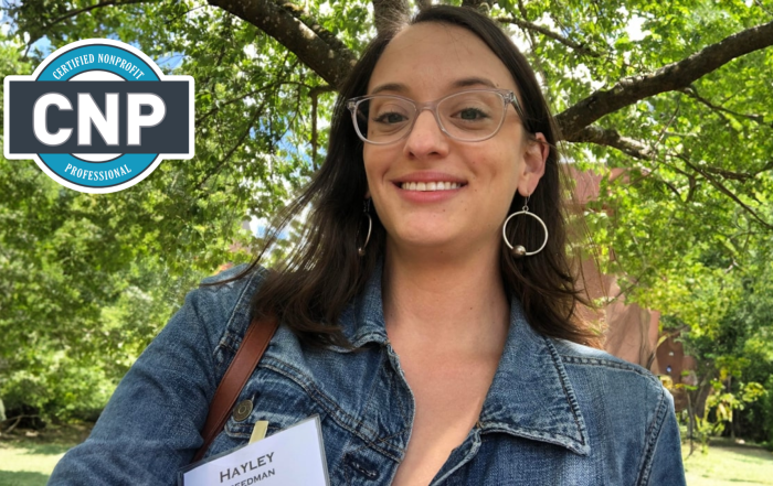 Hayley Freedman, Certified nonprofit Professional (CNP) smiling outside in front of a green tree