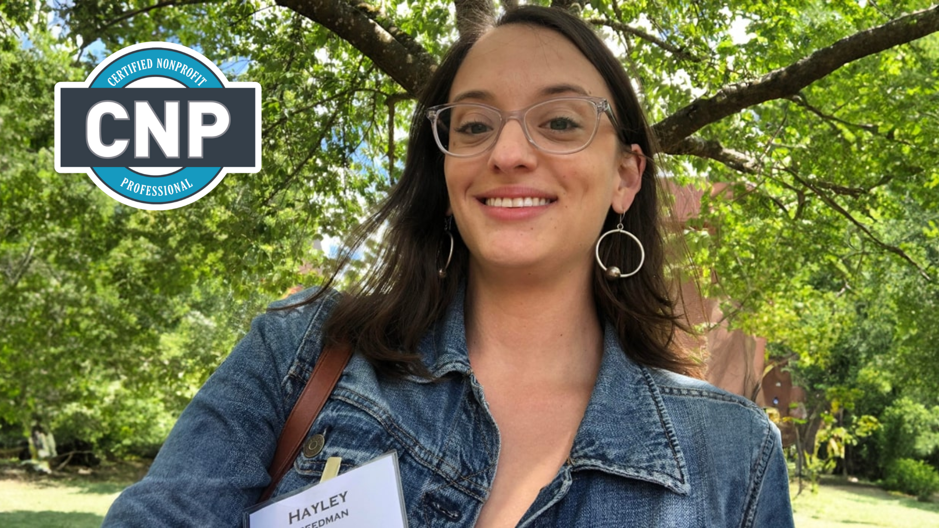 Hayley Freedman, Certified nonprofit Professional (CNP) smiling outside in front of a green tree