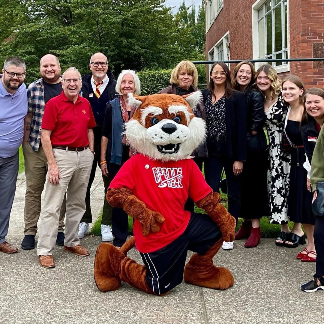 Freedman stands with alumni and Blitz the Bearcat back at Willamette University at the start of her year as Visiting Professor.