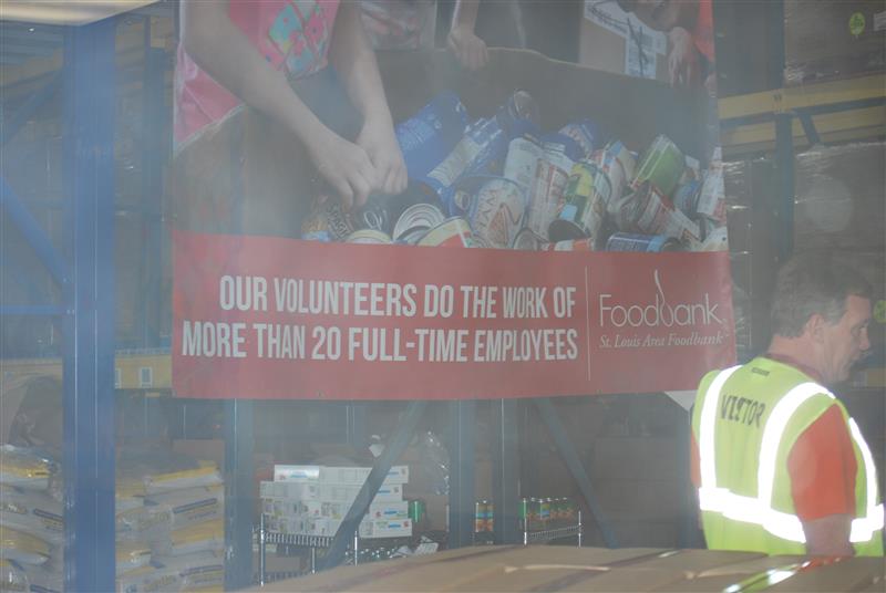 A St. Louis Food Bank staff member preparing industrial crates filled with boxes of nonperishable items to be distributed